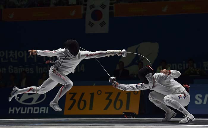 Japan's Kazuyasu Minobe (L) duels with South Korea's Jung Jinsun during the men's epee team fencing finals at Goyang gymnasium.