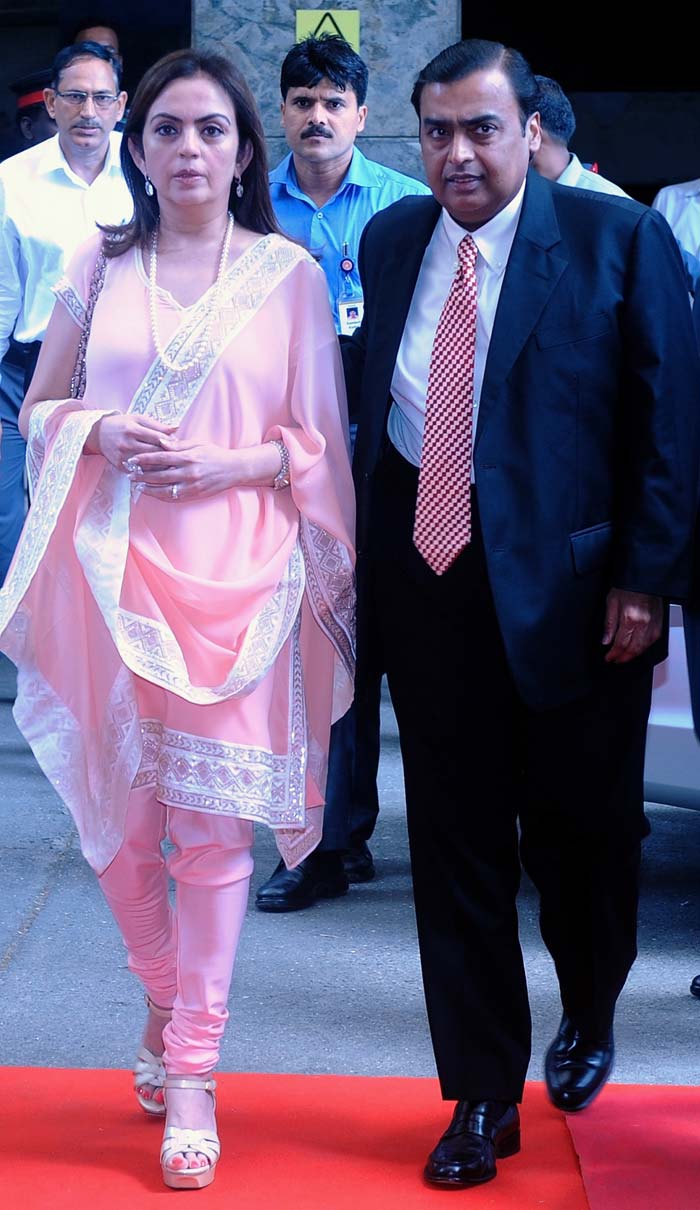 Reliance Industries chairman Mukesh Ambani arrives for the company's annual general meeting with his wife Nita in Mumbai. Ambani said at the meeting that the company will invest Rs 1 trillion over the next 10 years and aim to double operating profits in the next 4-5 years.