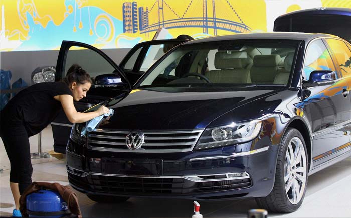 A worker cleans a Volkswagen car at the Auto Expo 2012.