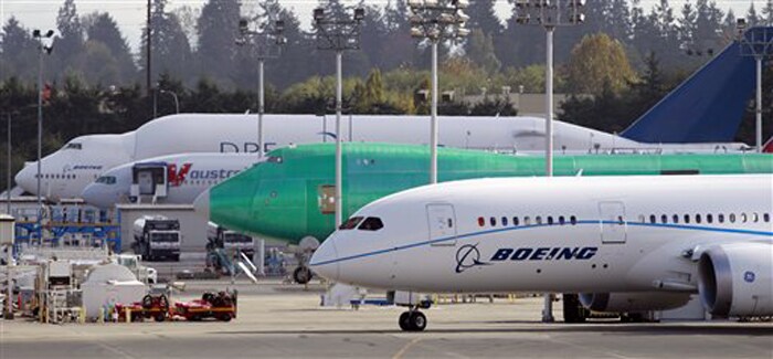 The Boeing 787 test plane, right, moves past other Boeing aircraft while heading into position for take-off on its first on October 4, 2010.