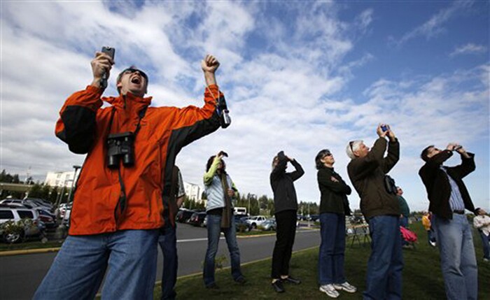 Tim Walsh, left, cheers as his wife pilots the sixth Boeing 787 test plane on its first flight overhead on October 4, 2010. (AP Photo)