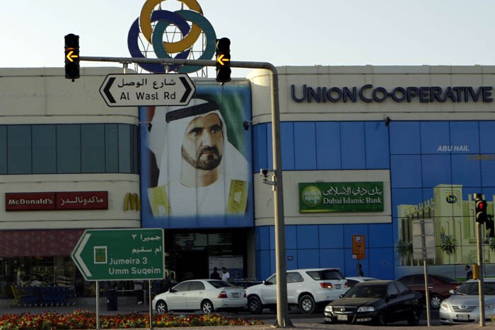 People pass by a giant poster of Sheik Mohammed bin Rashid Al Maktoum, UAE Prime Minister and ruler of Dubai in Dubai, United Arab Emirates. In separate moves that could portend longer-term instability, Standard & Poor?s downgraded Dubai-based banks with heavy exposure to Dubai World, and the Saudi-backed Gulf International Bank postponed a bond auction that was scheduled to be priced this week. (AP photo)