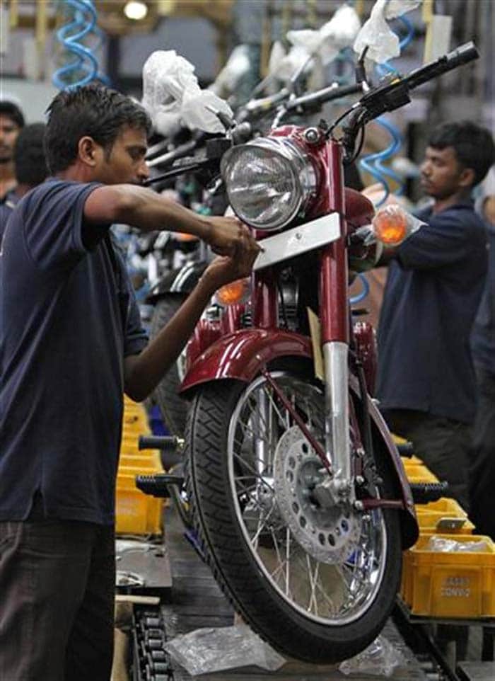 A worker fixes a number plate on a motorcycle. The company rolled out its first motorized bike in 1901 and entered the Indian market in 1949, where the Bullet, now in its 80th year of manufacture, became a staple on the country's roads.