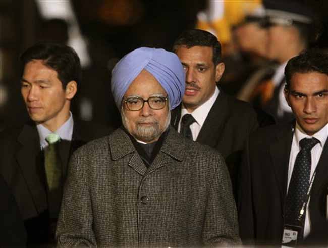 Indian Prime Minister Manmohan Singh walks to his limousine upon arriving  at Incheon International Airport in South Korea to attend the G-20 Summit.(AP)