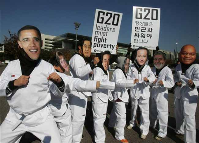 Activists of Oxfam International donning masks of the world leaders including US President Barack Obama, pose in Tae Kwon Do costume, during a performance to draw attention to global poverty issues, a day before the G-20 summit in Seoul. (AP)