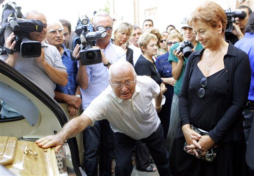 Enrica Fico, right, the widow of late Italian director Michelangelo Antonioni, looks on as an unidentified man touches the coffin of her husband, following the funerals at the St Giorgio cathedral in Ferrara,  Italy, Thursday, Aug 2, 2007.