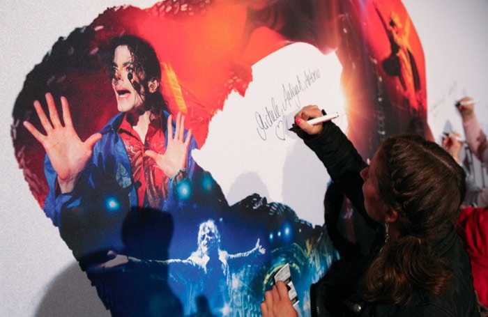 A fan of Michael Jackson adds her autograph to a board prior the premiere of the documentary "This Is It" in Berlin, Germany, late Tuesday, Oct. 27, 2009. When Jackson died in June, he was just days away from launching a 50-show run of comeback concerts in London. Now, video footage of preparations for those performances have become "Michael Jackson's This Is It," a documentary opening worldwide Tuesday and Wednesday. (Photo: AP)