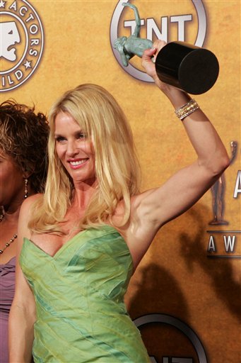 Actress Nicollete Sheridan raises her award as she and the cast of Desperate Housewives pose with the awards for outstanding performance by an ensemble in a comedy series at the 12th Annual Screen Actors Guild Awards.