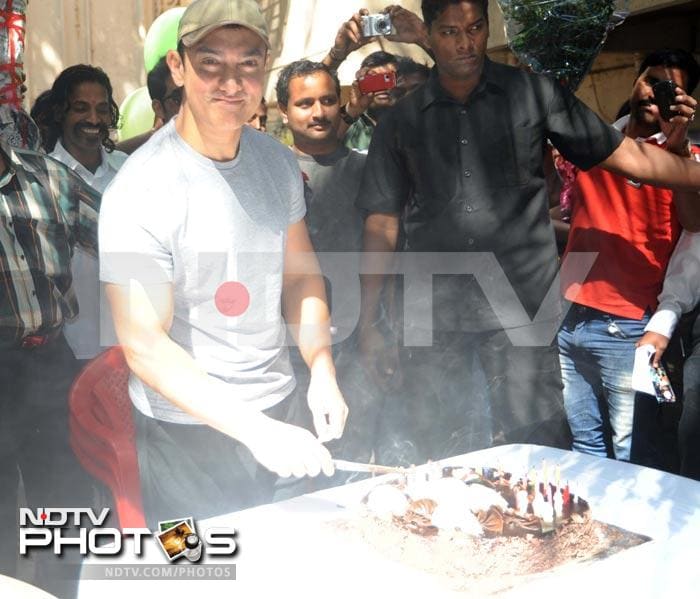 Aamir Khan, who turned 47 today, celebrated his birthday with the media and fans waiting outside his home in Mumbai. He cut a cake too.