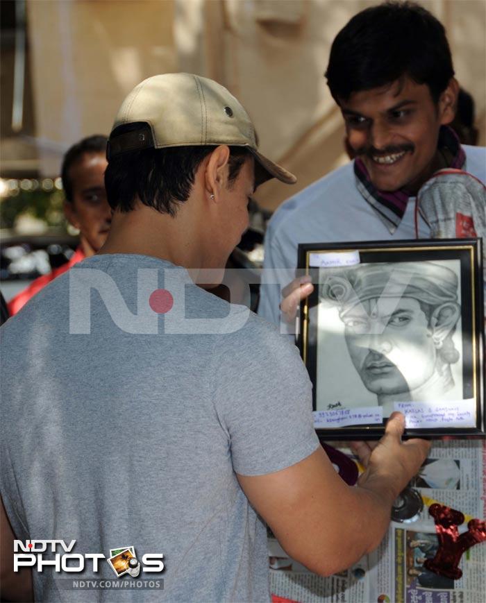 A fan gifts Aamir his portrait.