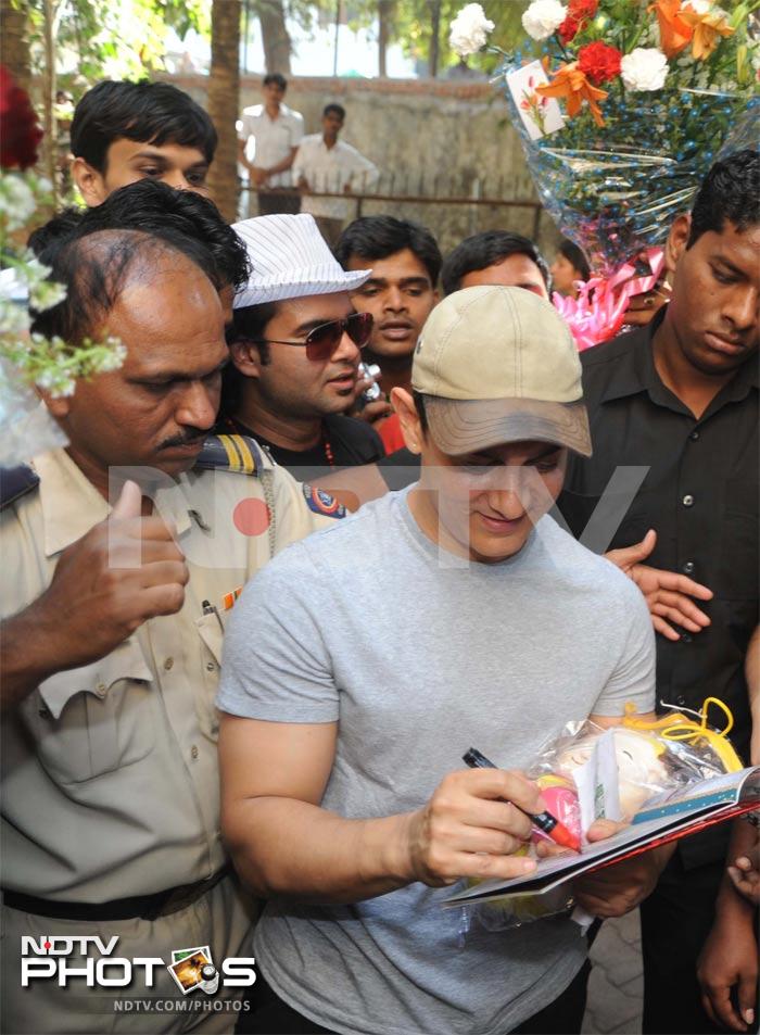 Aamir signs autographs for fans.