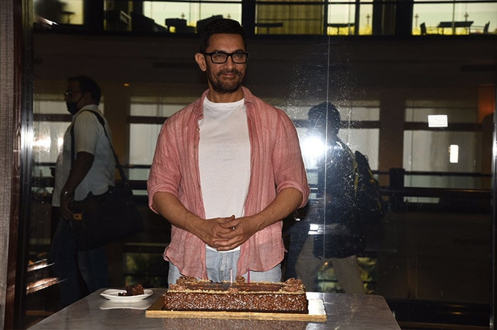 Birthday boy Aamir Khan looked dashing in a white t-shirt paired with blue jeans. He layered his look with an orange shirt.