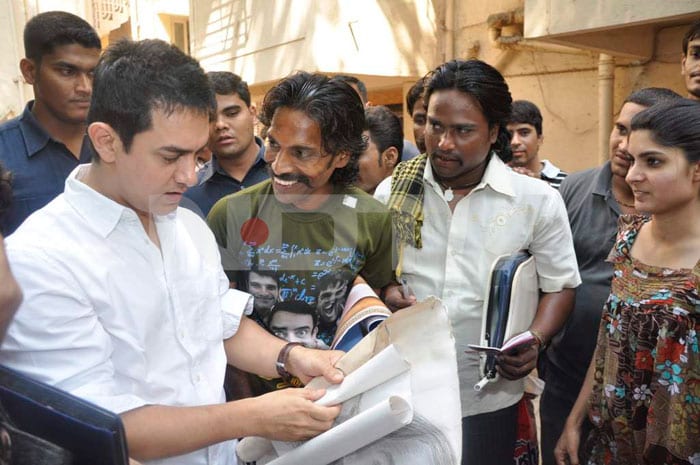 Aamir goes through a few paintings gifted to him by his fans.