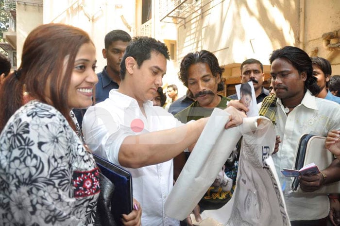 Aamir goes through a few paintings gifted to him by his fans.