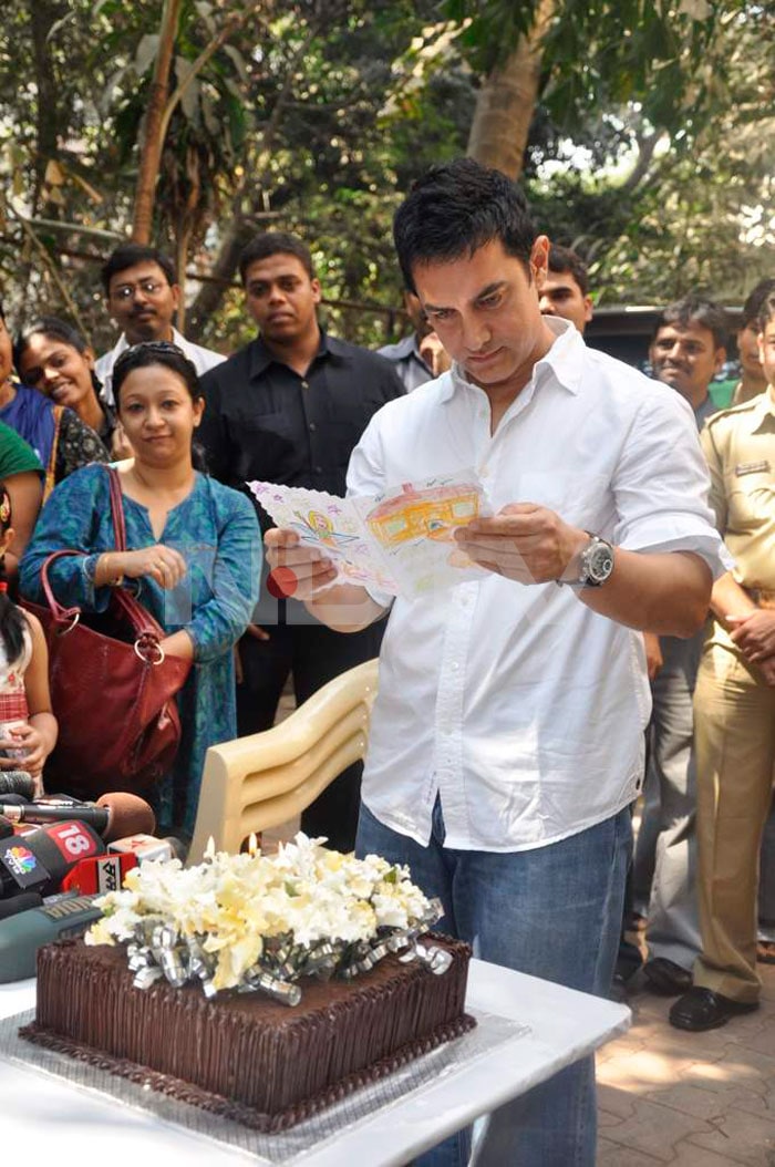 Aamir reads a birthday card made by one of his fans.