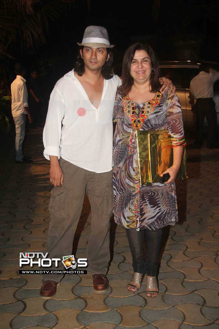 A Fedora sporting Shirish Kunder poses with wife Farah and they've even brought a gift.