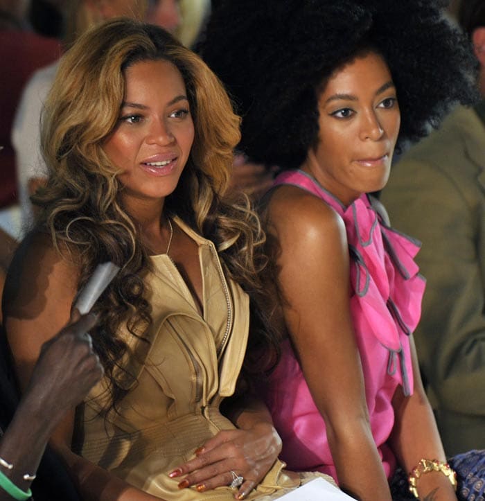 Beyonce holding her baby bump. Seen here with sister Solange.