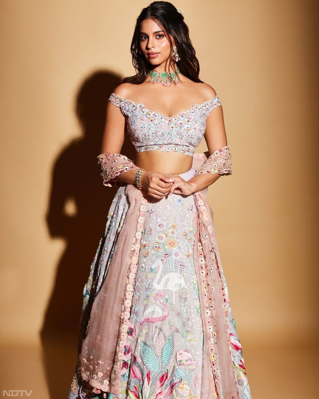 Suhana Khan shined in a white and pink lehenga adorned with detailed animal and floral motifs with an off-shoulder blouse that brought a stylish, contemporary flair to her otherwise traditional ensemble. (Instagram/@suhanakhan2)