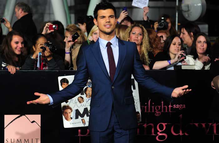 Actor Taylor Lautner gestures on arrival for the world-premiere of <i>The Twilight Saga: Breaking Dawn- Part 1</i>.