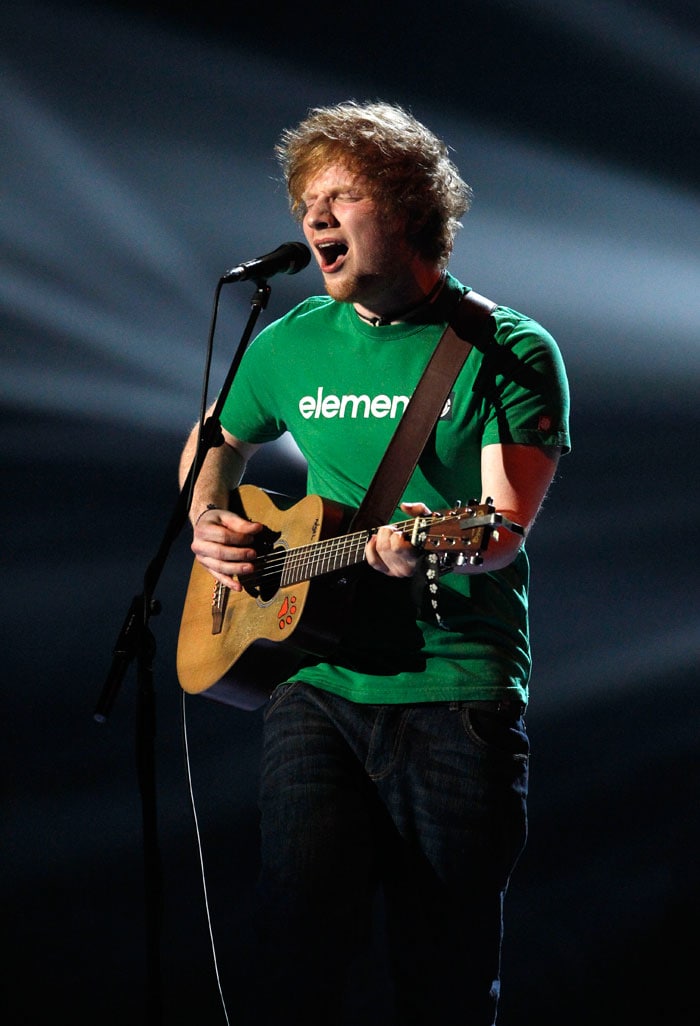 Tousle-haired singer-songwriter Sheeran performs on stage.