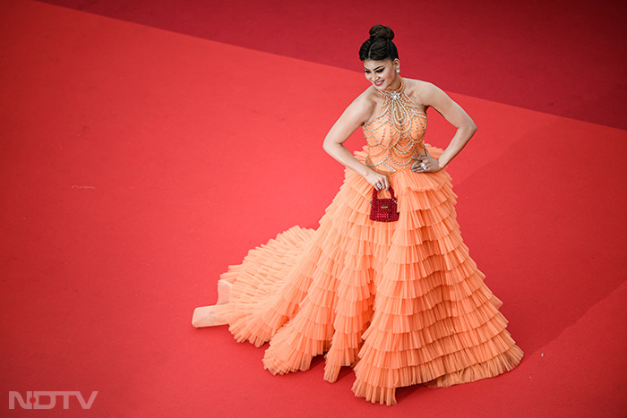 For her second red carpet appearance, Urvashi Rautela wore a bright orange ruffled gown with a silhouette. (Image Courtesy: AFP)