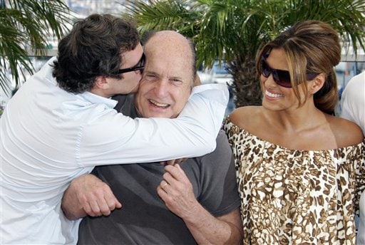 Actor Joaquin Phoenix, left, kisses Robert Duval, as Actress Eva Mendes looks on during a photo call for the film We Own the Night, at the 60th International film festival in Cannes.