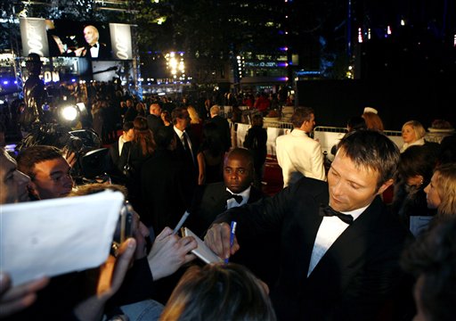 Danish actor Mads Mikkelsen, right, who plays Le Chiffre in the new James Bond film Casino Royale signs autographs as she arrives for the world premiere of the movie at a cinema in central London's Leicester Square.