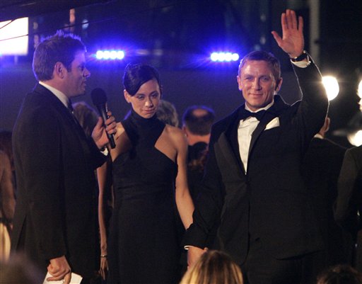 Actor Daniel Craig, right, the new James Bond, waves to fans as he arrives for the world premiere of the new James Bond film Casino Royale at a cinema in central London's Leicester Square