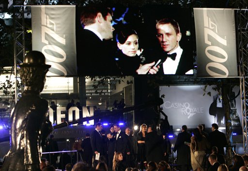 A statue of late British actor Charlie Chaplin is seen, left, as actor Daniel Craig, the new James Bond, is seen on stage and on screen giving an interview prior to the world premiere of the new James Bond film Casino Royale at a cinema in central London's Leicester Square. Casino Royale, the 21st James Bond film and the grittiest to date, was receiving its world premiere before an audience including Queen Elizabeth II -  reputedly a royal Bond fan.