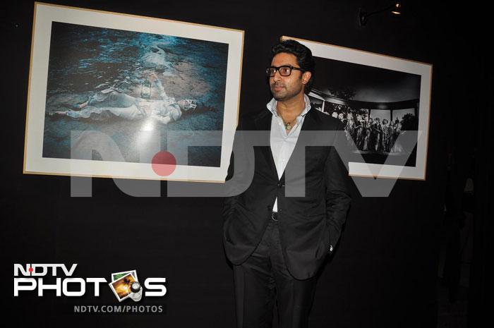 Abhishek Bachchan poses with the paintings in the background.