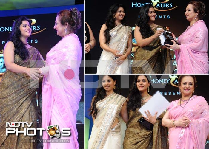 Kajol receives the Outstanding Performance Award on behalf of Ajay Devgn from Saira Banu.