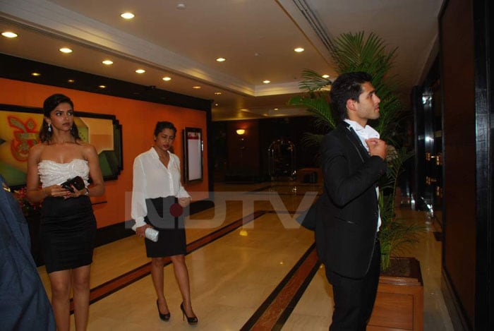 At Rahul Bose's Sports auction, the couple stood colour-coordinated. Sidhartha corrects his bow-tie as the lady looks on!