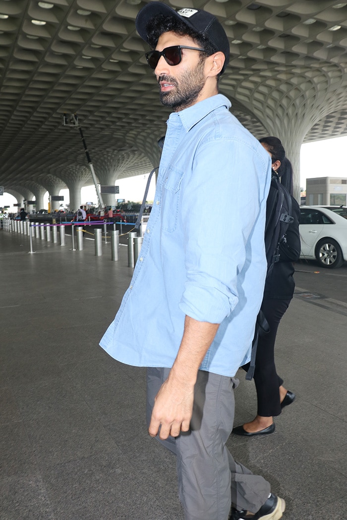 Aditya Roy Kapur was spotted at the airport, looking dapper in a denim shirt paired with grey pants. He completed his look with a black cap and sunglasses.