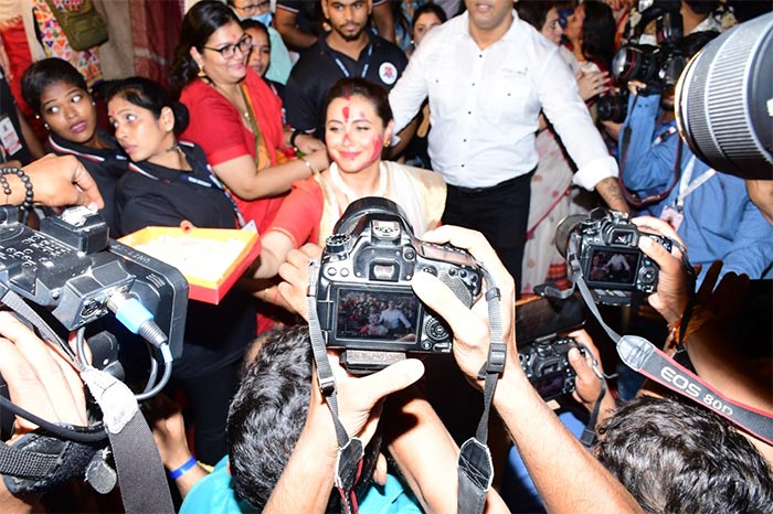 Rani distributed sweets to media at the pandal.