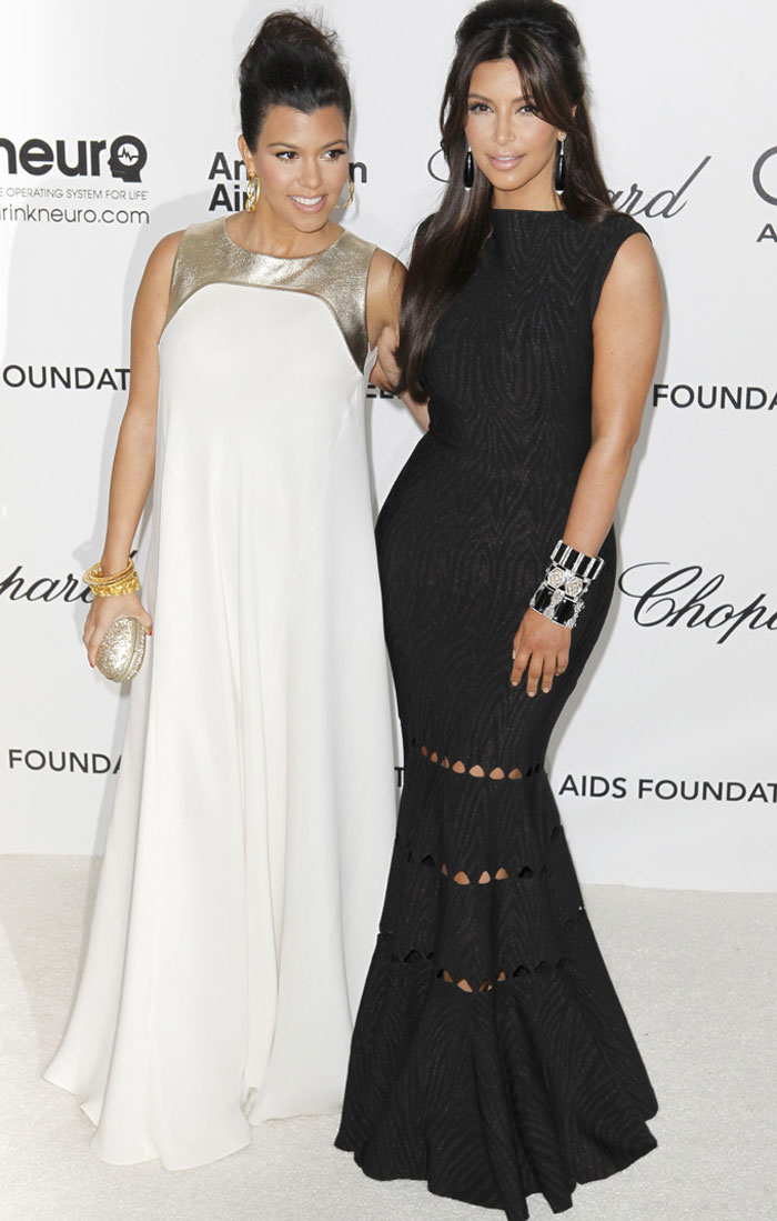 Kim K and her pregnant sister Kourtney smile for the shutterbugs. Kim K was in a dress by Alaia and Kourtney wore a Raoul dress.