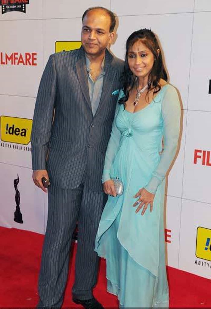 Ashutosh Gowariker and Sunita, 2010: Yes, dresses like this exist. But why would you sew up yards of cheap material, team it with some obviously artificial jewellery and then not even wash your hair? At least some lipstick, please?