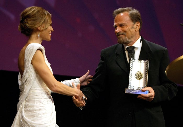 US actress Hilary Swank shakes hands with Italian actor Franco Nero, after he received on behalf of his wife British actress Vanessa Redgrave, a Lifetime Achievement award at the opening of the Middle East International Film Festival (MEIFF) in Abu Dhabi, on October 8, 2009. (Photo: AFP)