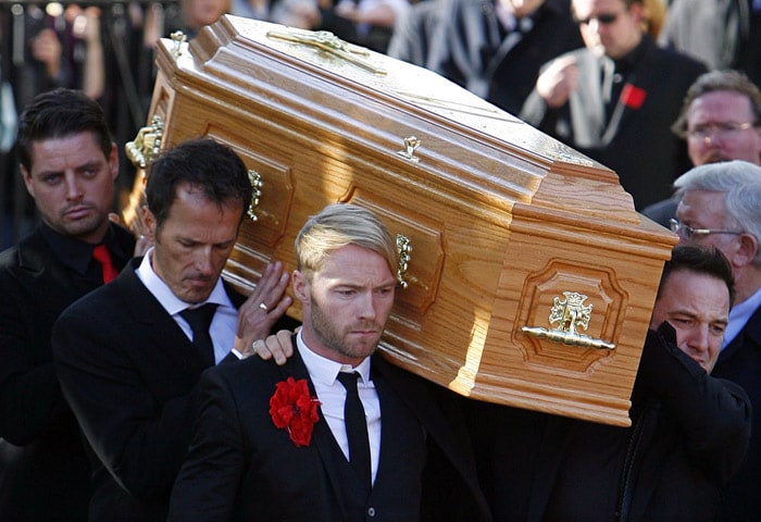 The coffin carring the body of Stephen Gately, the Irish singer from pop group Boyzone, is carried by band members Ronan Keating (Front L) Keith Duffy (Back L) and Mickey Graham (Front R) after a funeral at St Laurence O'Toole's Church in Dublin, on October 17, 2009. Hundreds of fans gathered in Dublin Saturday for the funeral of Boyzone star Stephen Gately, paying the singer an emotional farewell one week after his death at the age of 33 shocked the pop world. His bandmates, friends and family packed into St Lawrence O'Toole's church near Gately's home in the north of the Irish capital for the funeral service, while outside, tearful crowds held white roses and left flowers in tribute. (Photo: AFP)