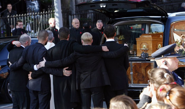 Members of Boyzone and family embrace in front of the coffin carring the body of Stephen Gately, the Irish singer from pop group Boyzone outside of St Laurence O'Toole's Church in Dublin, on October 17, 2009. An autopsy on Stephen Gately revealed that he died due to excess fluid in his lungs, a court spokeswoman on the Spanish island of Majorca said on October 13. Gately, 33, was found dead on October 10 in his apartment in the Majorcan town of Port Andratx while on holiday on the Mediterranean island. News reports said he had been out late the night before. Gately, who married his partner Andrew Cowles in a civil union in 2006, sent ripples through the pop music world 10 years ago when he announced that he was gay. (Photo: AFP)