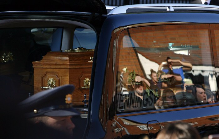 Members of the public are reflected in the hearse window carrying the coffin of Stephen Gately, the Irish singer from pop group Boyzone from St Laurence O'Toole's Church in Dublin, on October 17, 2009. An autopsy on Stephen Gately revealed that he died due to excess fluid in his lungs, a court spokeswoman on the Spanish island of Majorca said on October 13. Gately, 33, was found dead on October 10 in his apartment in the Majorcan town of Port Andratx while on holiday on the Mediterranean island. News reports said he had been out late the night before. Gately, who married his partner Andrew Cowles in a civil union in 2006, sent ripples through the pop music world 10 years ago when he announced that he was gay. (Photo: AFP)