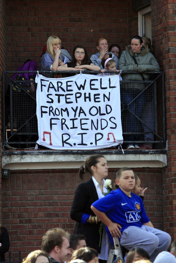 Members of the public watch the coffin carrying the body of Stephen Gately, the Irish singer from pop group Boyzone being carried from St Laurence O'Toole's Church in Dublin, on October 17, 2009. An autopsy on Stephen Gately revealed that he died due to excess fluid in his lungs, a court spokeswoman on the Spanish island of Majorca said on October 13. Gately, 33, was found dead on October 10 in his apartment in the Majorcan town of Port Andratx while on holiday on the Mediterranean island. News reports said he had been out late the night before. Gately, who married his partner Andrew Cowles in a civil union in 2006, sent ripples through the pop music world 10 years ago when he announced that he was gay. (Photo: AFP)