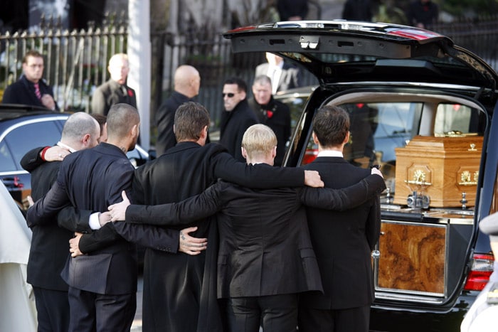 Members of Irish band Boyzone, look at the  coffin of fellow band member Stephen Gately after a funeral service at St. Laurence O'Toole Church, after the funeral service, in Dublin, Ireland, Saturday Oct. 17, 2009. Gately was found dead on Saturday, Oct. 10, 2009, in a house near Port d'Andratx on the western tip of Mallorca. The singer had gone to Mallorca with his partner Andrew Cowles. The two were wed in a civil union in 2006. Autopsy results released on Tuesday showed Gately died of natural causes. Photo of Gately seen on the right. (Photo: AP)