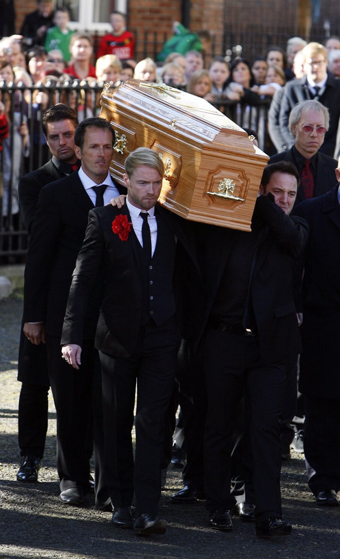 The coffin carrying the body of Stephen Gately, the Irish singer from pop group Boyzone is carried by Ronan Keating (front L), Unidentified (middle L), Kieth Duffy (back L) and Mickey Graham (R) from St Laurence O'Toole's Church in Dublin, on October 17, 2009. An autopsy on Stephen Gately revealed that he died due to excess fluid in his lungs, a court spokeswoman on the Spanish island of Majorca said on October 13. Gately, 33, was found dead on October 10 in his apartment in the Majorcan town of Port Andratx while on holiday on the Mediterranean island. News reports said he had been out late the night before. Gately, who married his partner Andrew Cowles in a civil union in 2006, sent ripples through the pop music world 10 years ago when he announced that he was gay. (Photo: AFP)