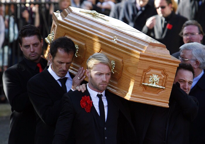 The coffin carrying the body of Stephen Gately, the Irish singer from pop group Boyzone is carried by Mickey Graham (L) Undentified (C), and Shane Lynch (R) from St Laurence O'Toole's Church in Dublin, on October 17, 2009. An autopsy on Stephen Gately revealed that he died due to excess fluid in his lungs, a court spokeswoman on the Spanish island of Majorca said on October 13. Gately, 33, was found dead on October 10 in his apartment in the Majorcan town of Port Andratx while on holiday on the Mediterranean island. News reports said he had been out late the night before. Gately, who married his partner Andrew Cowles in a civil union in 2006, sent ripples through the pop music world 10 years ago when he announced that he was gay. (Photo: AFP)