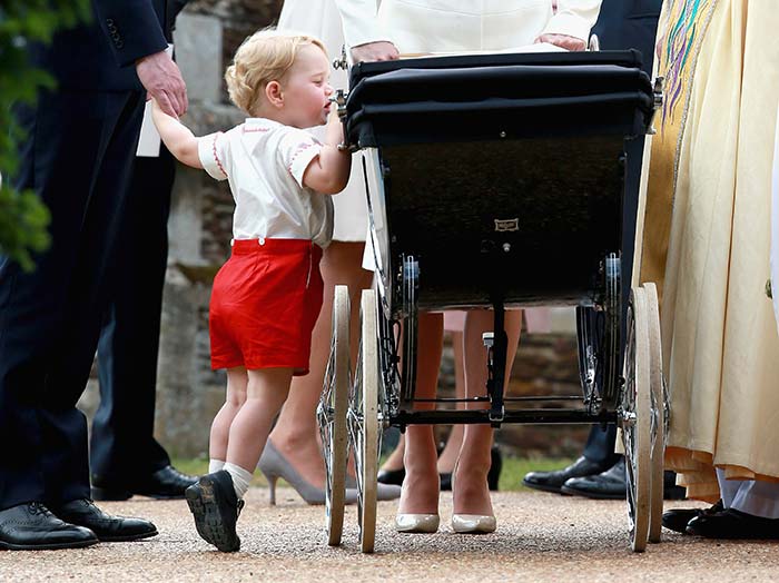 Prince George of Cambridge attempts to get a glimpse of sister Charlotte at her christening at St Mary Magdalene Church in England.