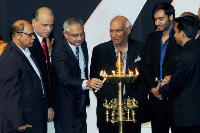 Goa Chief Minister Digambar Kamat, filmmaker Yash Chopra (C), actor Ajay Devgn and others look on as Raghu Menon, Secretary, Ministry of Information & Broadcasting, lights the lamp during the inauguration of the 41st International Film Festival (IFFI-2010) in Panaji, Goa. (Photo: PTI)