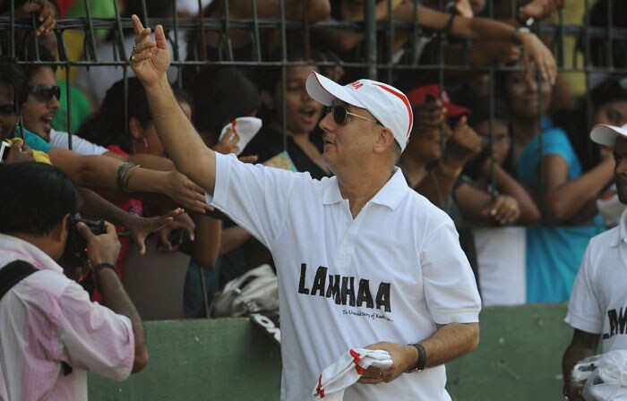 Veteran actor Anupam Kher gives away caps to the crowd during a cricket match between Indian Bollywood actors and Sri Lankan cricketers during the three day International Indian Film Academy (IIFA) awards events in Colombo on June 4, 2010.