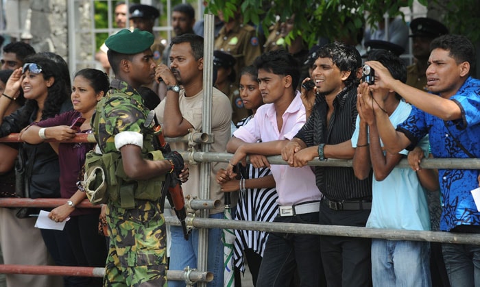 A Sri Lankan soldier stands guard as fans wait to catch a glimpse of Bollywood personalities outside the stadium where a cricket match between Indian Bollywood actors and Sri Lankan cricketers are being held during the three day International Indian Film Academy (IIFA) awards events in Colombo on June 4, 2010.