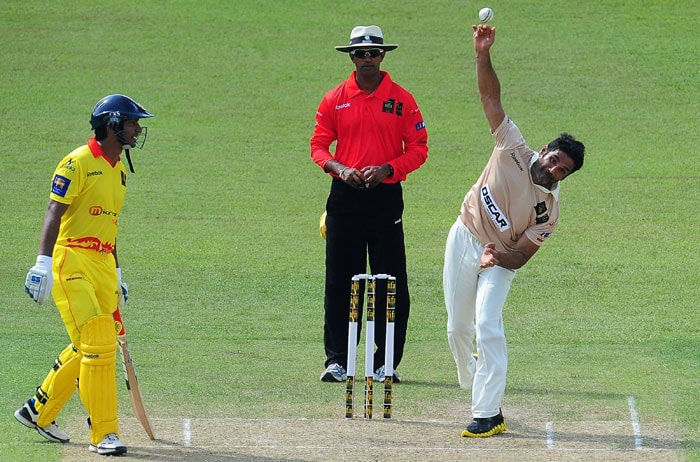 Sunil Shetty (R) delivers the ball as Sri Lankan cricketer Kumar Sangakara (L) looks on during a cricket match between Indian Bollywood actors and Sri Lankan cricketers during the three-day International Indian Film Academy (IIFA) awards events in Colombo on June 4, 2010.
