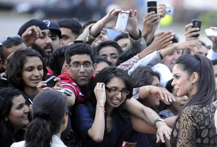 Mallika Sherawat greets fans as she walks the green carpet for the world premiere of <i>Double Dhamaal</i>, ahead of the 2011 International Indian Film Academy (IIFA) awards in Toronto.